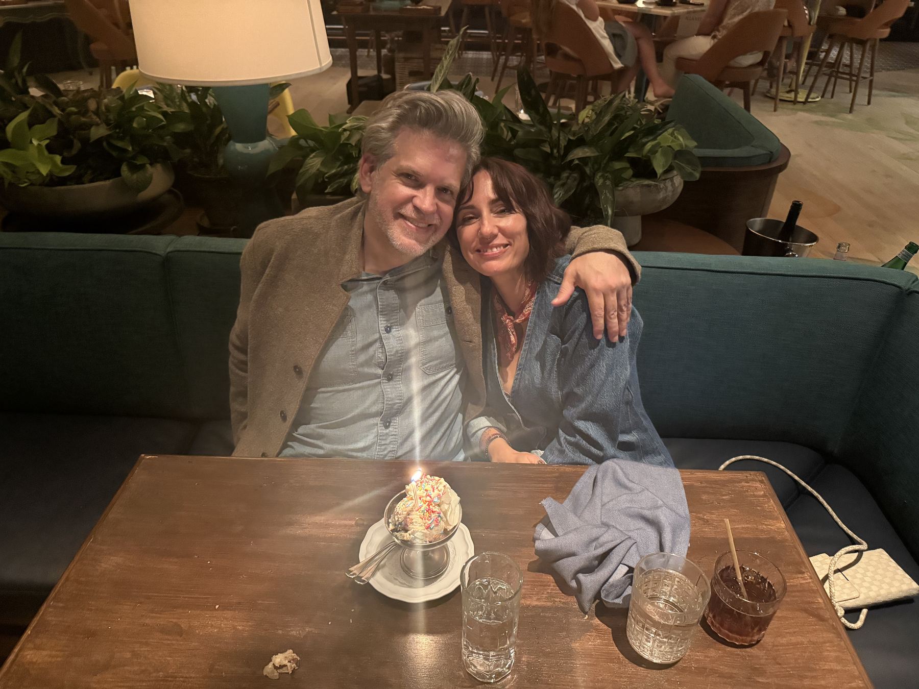 Danielle and Patrick celebrating with dessert and candlelight at a restaurant